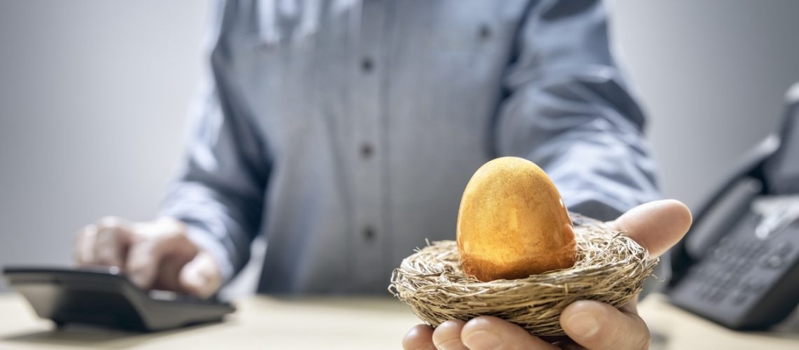 Retirement savings golden nest egg in a mans hand
